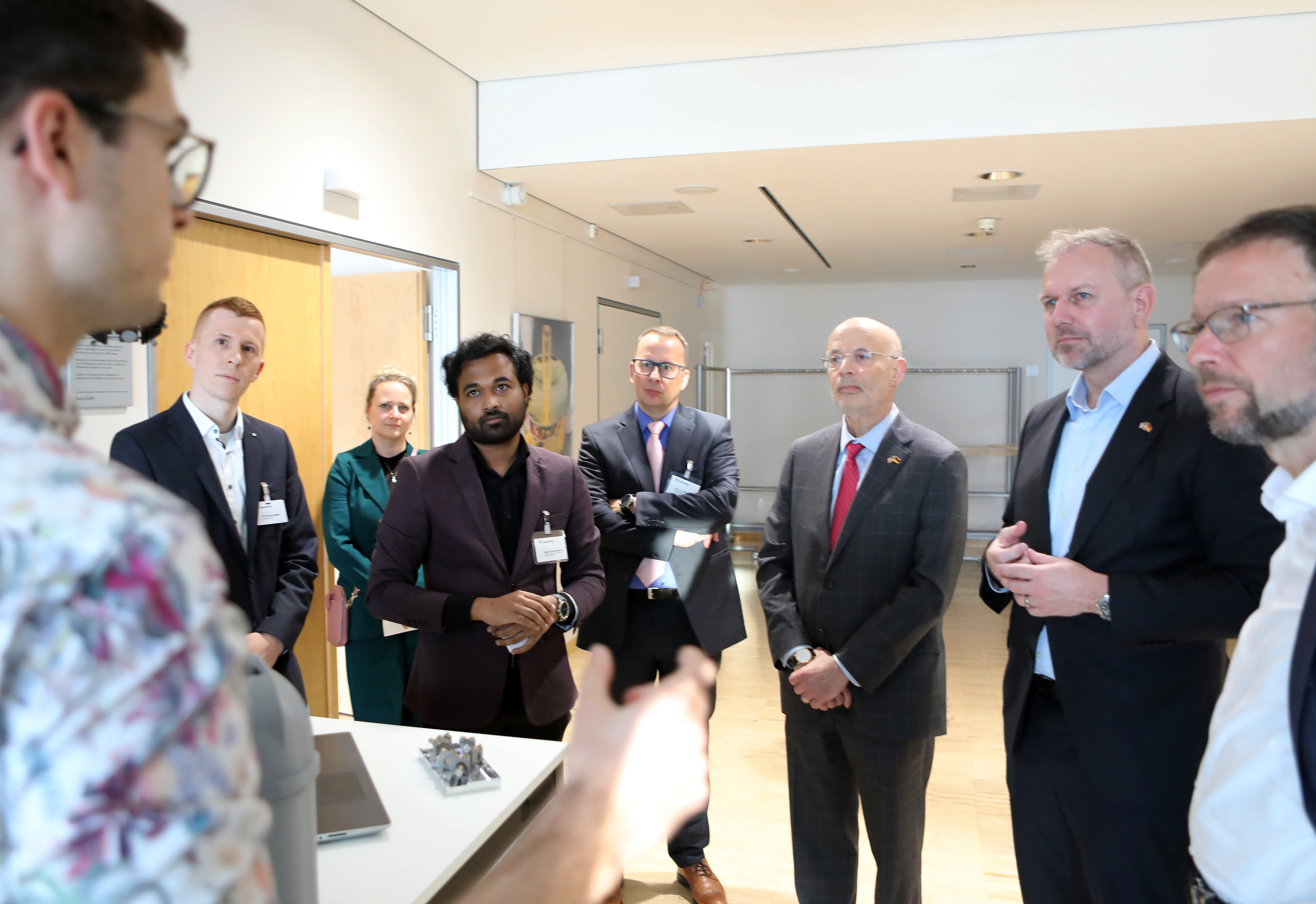 Thomas Nitzsche, John R. Crosby and Alan Meltzer (from right to left) inform themselves about the main research areas of the Fraunhofer IOF 